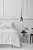 Schlafzimmer im Pariser Stil mit getäfelten Wänden, weißen Böden und weißer Bettwäsche