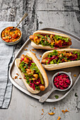 Vegane 'Hot Dogs' mit eingelegten Zwiebeln und Tomaten-Mango-Chutney