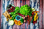 Summer vegetables and summer fruit on a colored wooden background