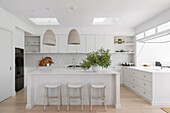 White corner kitchen and kitchen island in an open living room