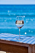 Ein Glas Weißwein auf Tisch am Meer