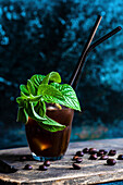 Frothy Whipped Coffee White Russian cocktail served in the glass and decorated with coffee beans and fresh mint leaves