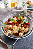 Grilled chicken on a skewer, served with caprese salad