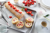 Sponge cake roulade with whipped cream and fresh strawberries