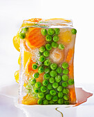 Peas, apricots and carrots in a block of ice
