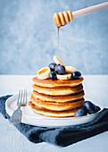 Pancakes with banana, blueberries and maple syrup