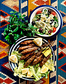 Salad with sesame dressing and ground beef kabobs (Cyprus)