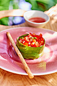 Tomato tartare with goji berries in a banana leaf cup