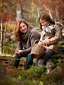 Mutter und Tochter beim Pilze sammeln im Wald