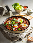 Shakshuka with black beans, butter-fried bread croutons and pickled chili
