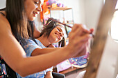 Happy mother and disabled daughter painting together at home