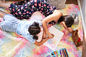 Mother and daughter drawing circles in notebook