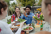 Friends enjoying vegetarian lunch at patio table