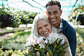 Happy couple with flowers in garden shop