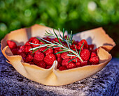 Waffle bowl filled with red berries and rosemary