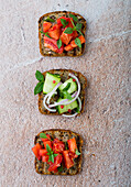 Grilled slices of bread with fresh tomatoes, cucumbers, and red onions
