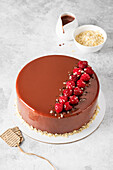 Chocolate mirror glaze cake decorated with raspberries