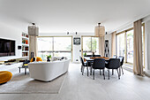 Dining area with black chairs and lounge with a white couch in an open plan living area