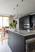 Elegante Küche mit schwarzen Schrankfronten und Granit-Arbeitsplatte