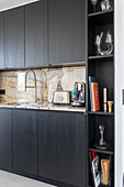 Elegante Küche mit schwarzen Schrankfronten und Granit-Arbeitsplatte