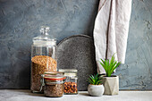 Raw food ingredients on the modern kitchen table with cactus plants in the cement pots