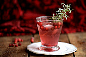 Cranberry tonic, garnish with a small snowy mini spruce twig in the form of sugared rosemary
