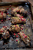Chicken wings with pepper, pomegranate seeds, and lemon zest