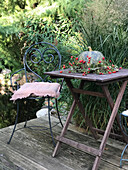 Wooden table with pumpkin and rosehip wreath on the terrace