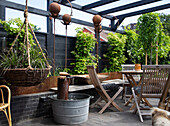 Seating area, planted hanging baskets, and rusty decorations on the terrace