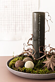 Christmas arrangement with calendar candle, DIY beaded balls and moss on plate