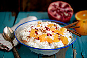 Rice dessert with pomegranate seeds, oranges, and cinnamon