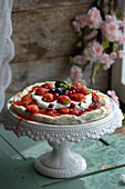 PistachioPavlova with rhubarb cream and lots of berries becomes a brilliant midsummer dessert