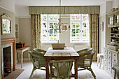 Wicker chairs at the wooden table in the dining room