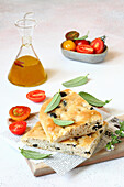 Focaccia with semolina, olives, and aromatic herbs