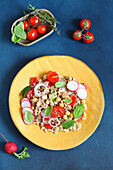 Spelt salad with chickpeas, tomatoes, and radishes