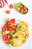 Pancakes with tomatoes and radishes