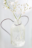 Blumen in einem Glas mit Herzdekoration