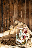 Ein Glas gefüllt mit Tannenbäumchen und einem Wichtel, Weihnachtsdekoration