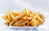 A bowl of French fries on a light background