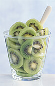 Glass with kiwi slices against a light background