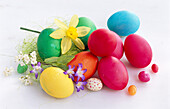 Colorful Easter eggs with daffodils and other spring flowers