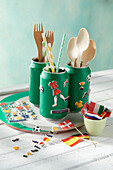 Decorations for the soccer party evening - decorated tins for cutlery, flags, and stickers