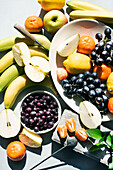 Obststillleben mit Bananen, Birnen, Äpfeln, Mandarinen, Trauben und Beeren