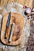 Knife and whetstone on wooden chopping board