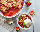 Rhabarber-Erdbeer-Crumble serviert mit Eis