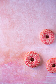 Donuts mit rosa Zuckerguss auf rosa Untergrund
