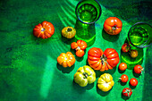 Verschiedene Tomaten aus eigenem Anbau auf grünem Untergrund
