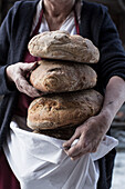 Bäckerin mit frisch gebackenen Brotlaiben