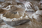 Shovel of flour and hands kneading bread dough