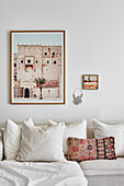 White seating furniture with linen cover and cushions, artwork hung on the wall